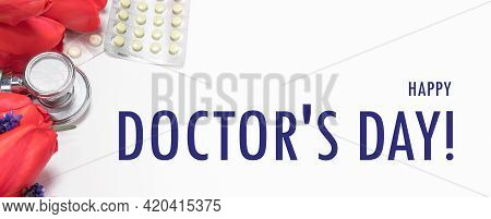 Flowers, Phonendoscope And Tablets - A Banner With Inscription Happy Doctor's Day On White