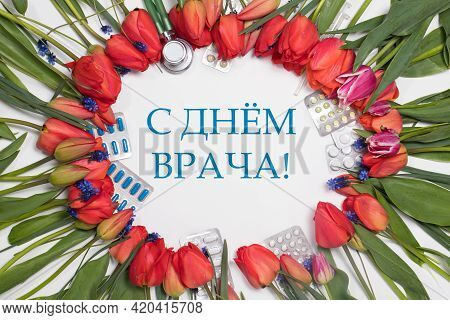 A Frame Of Tulips And Medicine Tablets With Inscription Translation From Russian Happy Doctors Day.