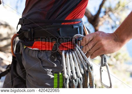 Climbing Equipment On A Male Climber: Rock Shoes, Rope, Quickdraw, Safety Device, Harness. Sports Mo