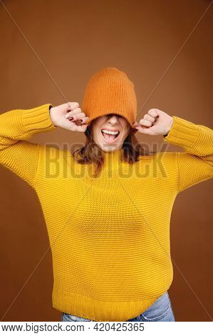 A Portrait Of A Cheerful Happy Girl With Light Brown Long Hair Having Fun, Covering Her Eyes With A 