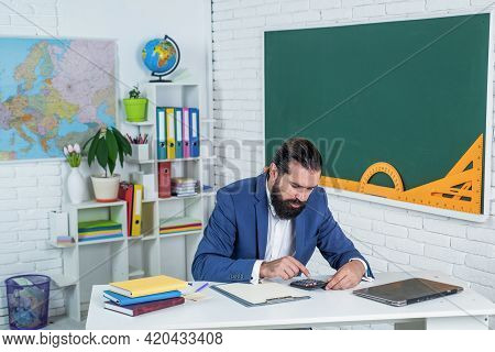 Brutal Bearded Man Work In Classroom With Calculating Machine. Prepare For Exam. College Lecturer On