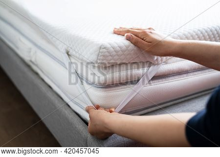 Mattress Topper Being Laid On Top Of The Bed