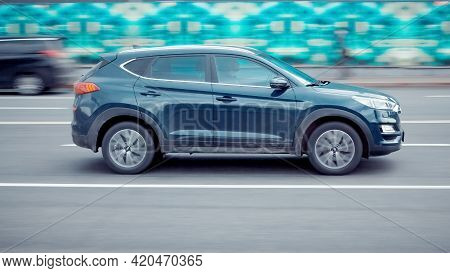 Fast Moving Suv Rides On A Highway Road. A Car On Asphalt Road In Motion. Overspeed In City Concept.