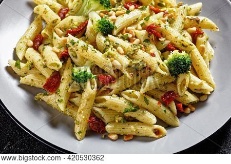 Broccoli Pesto Penne Pasta With Sundried Tomatoes And Pine Nuts On A Plate, Horizontal View From Abo