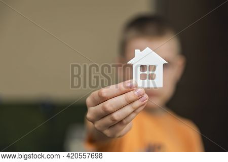 Orphanage, Children In The Orphanage. The Child Is Holding A Small House-shaped Figurine, Close-up. 