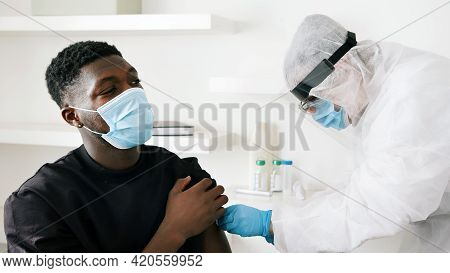 Covid-19 Or Coronavirus Vaccine. Vaccinating Citizens. Doctor Holding A Syringe And Wearing A Face A