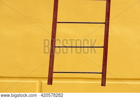 Old Ladders On Blank Yellow Wall. Yellow Abstrast