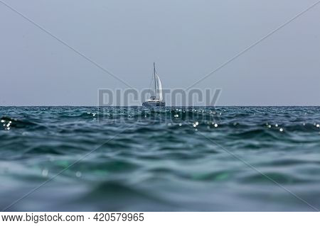 White Sailing Boat Catamaran On Ocean Near Beach.