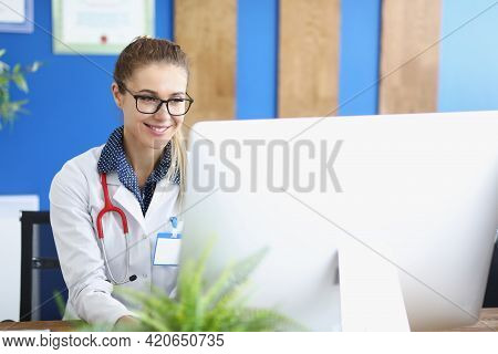 Portrait Of Smiling Doctor With Glasses Conducting Online Medical Consultation