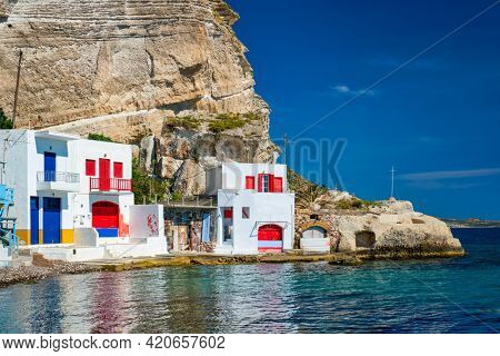 Scenic picturesque greek fishing village Klima with whitewashed traditional houses and colorful windows and doors on Milos island in Greece