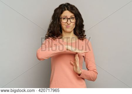 Studio Portrait Of Dissatisfied Embarrassed Woman Show Timeout Hand Gesture. Tired Casual Business F