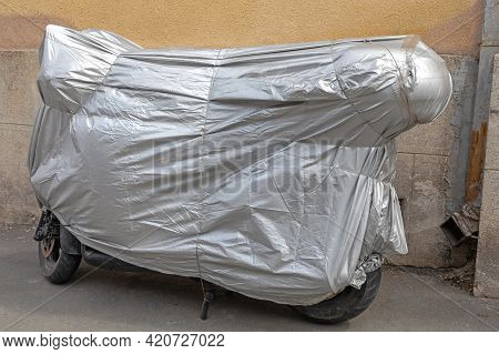 Packed Motorcycle Under Silver Tarp Cover Winter Storage