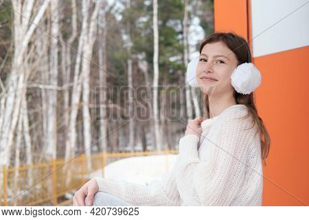 Teenager Girl Sitting On A Staicase Of A Forest Modern House And Looking At Camera. Girl Wearing Whi