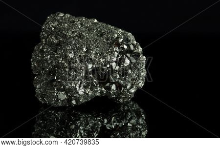A Cluster Of Pyrite Crystals. Isolated On A Black Mirror Background.