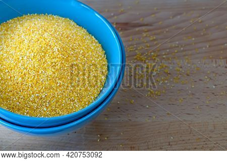 Corn Grits In A Blue Cup. Groats For Cooking Porridge.
