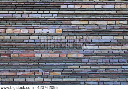 Surface And Texture Of Multy-colored (colorful) Decorative Stone Wall, Background. Varicolored Flat 