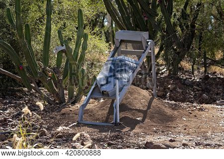 Abandoned Sapphire Mining Sieve Amongst Rocks And Cacti On Fossicking Field