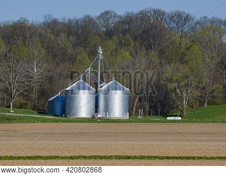 Silos Shine In Early Morning Spring Light At The Edge Of A Farm Firld In Parke County, Indiana