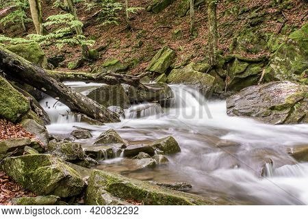 Mountain Stream In The Woods With A Stone On A Long Exposure. Beautiful Nature.
