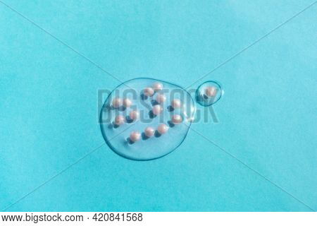Cosmetic Gel Swatch Isolated On Blue Background. Transparent Fluid With Pink Particles. Liquid Smear