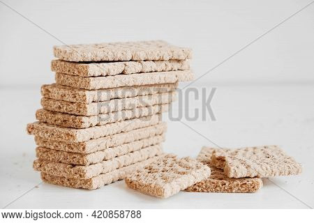 Stacked Rye Crisp Bread On A White Wooden Background. Copy, Empty Space For Text