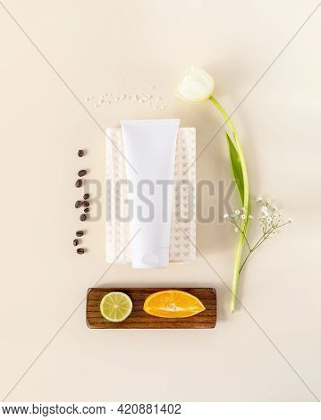 Vertical Composition With Cosmetic Tube On A White Towel, Tulip, Orange, Laim And Coffee Beans. The 