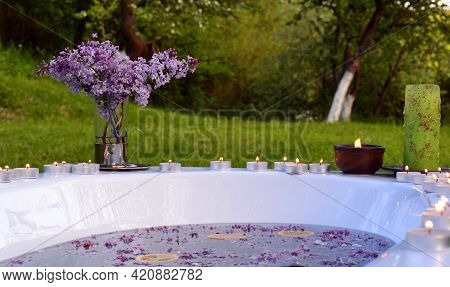 Romantic Background With Lilacs Flowers And Orange Slices In A Bathtub Outdoor