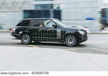 Brand New Range Rover L405 Side View. Sport Suv Black Color Driving Against A Background Of Glass Bu