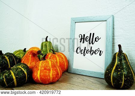 Hello October Typography Text With Pumpkin Decoration On Wooden Table
