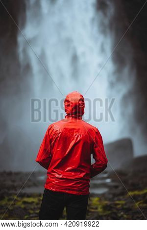 Man in a red windbreaker at the Haifoss waterfall, Iceland