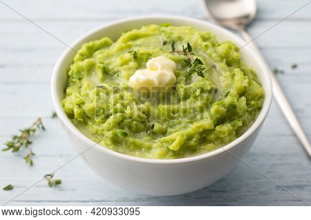 Delicate Mashed Potatoes With Green Peas, Flavored With Butter, Spices And Thyme On A Light Blue Bac