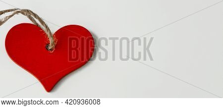 Wooden Red Heart On A String, On A White Background.