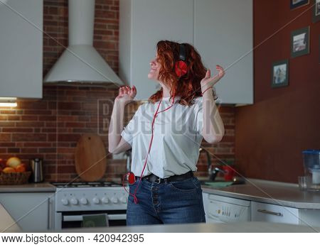 Overjoyed Millennial Woman Have Fun In Home Kitchen.