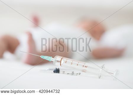 Syringe With Blur Baby Background. Vaccine Antivirus For Infant 
Concept