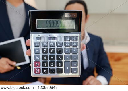 Man Holding Calculator In Hand. Business Man Showing Value On Calculator.
