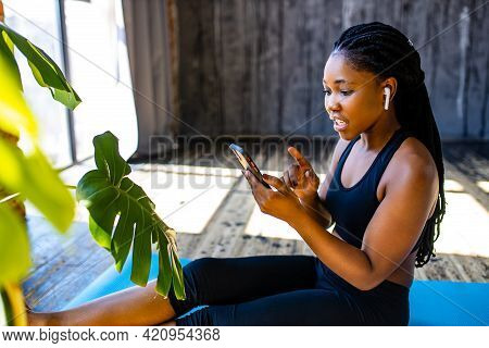 African American Woman In Black Sporty Bra With Yoga On Mat Listening An Audio Meditate Mantra
