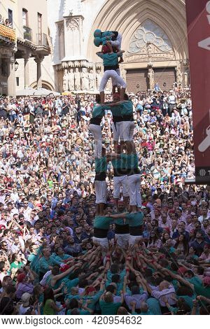 Tarragona, Spain, September 19, 2019 - Children Climb To Top Of Human Castells Tower. Crowd Of Spect