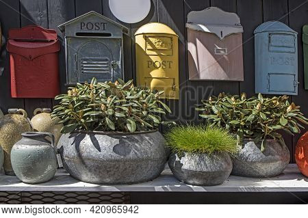 Selection Of Clay Amphorae And Pots Of Various Shapes And Colors On A Shelf Against The Background O