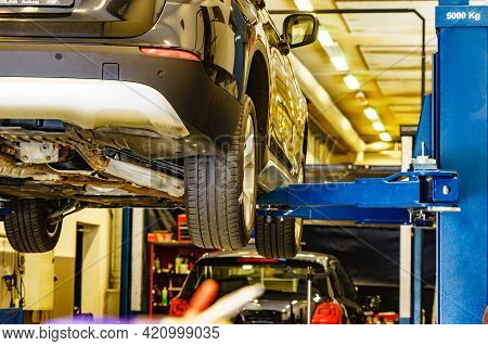 Car In Service. Auto Raised On Lift In Autoservice.