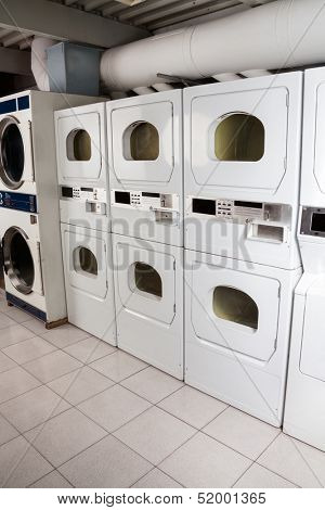 Row of self-service clothes dryers in laundry
