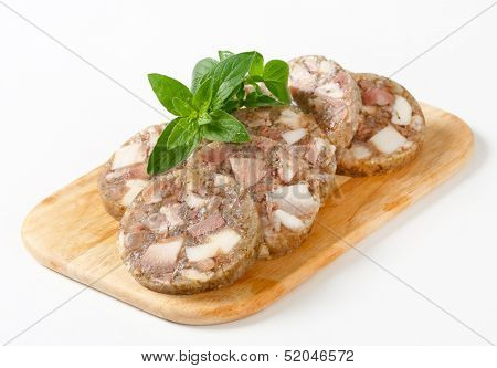 Sliced head cheese on a cutting board