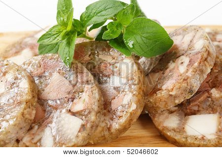 Sliced head cheese on a cutting board