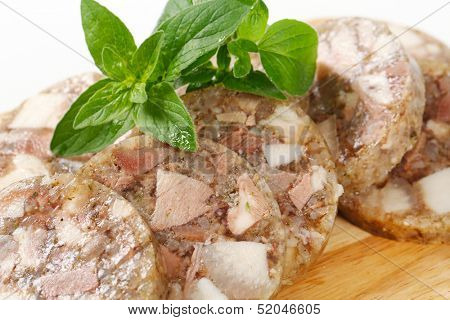 Sliced head cheese on a cutting board