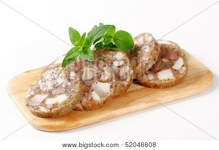 Sliced head cheese on a cutting board