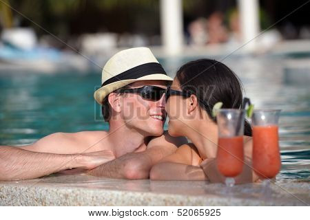 happy young couple relax and take fresh drink at summer vacation on swimmin pool