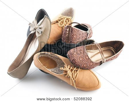 Pile of various female flat shoes isolated over white