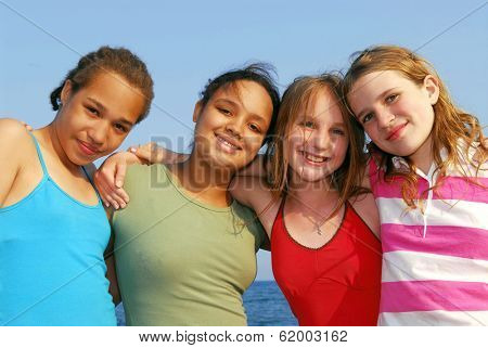 Portrait of four smiling teenage girls outside