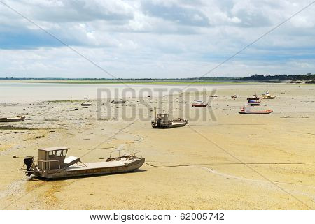 Fishing boats on the ocean floor at low tide in Cancale (Brittany, France)