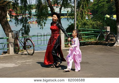 Mother Holding Hand Children Walking In Park