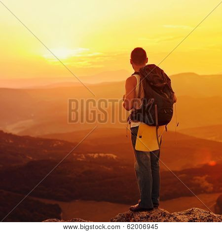 Guy In The Mountains At Sunset. The Concept Of Freedom